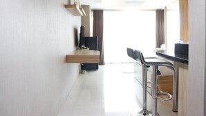 Une cuisine moderne avec un coin bar, une table à manger et un téléviseur fixé au mur.