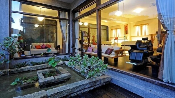 A modern interior with a seating area, a massage chair, and a small water feature.