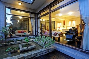A modern interior with a seating area, a massage chair, and a small water feature. - Windsor's Vanilla Garden B&B (New Taipei City)