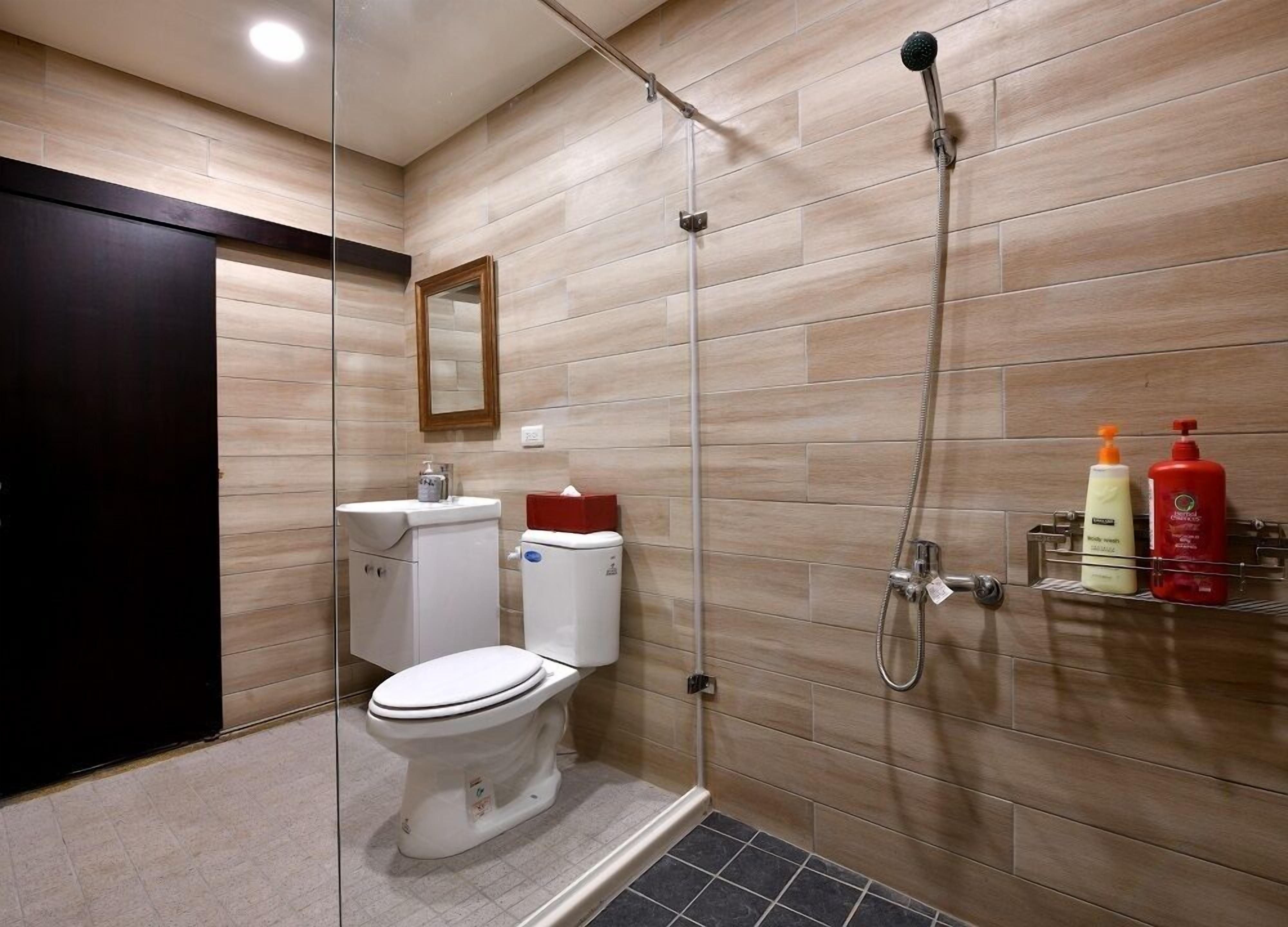A modern bathroom with a toilet, bidet, and shower.