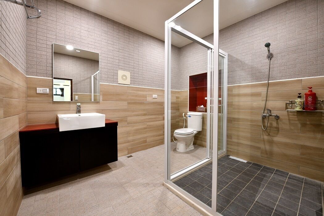 A modern bathroom with a glass-enclosed shower, a wooden vanity, and a large mirror.