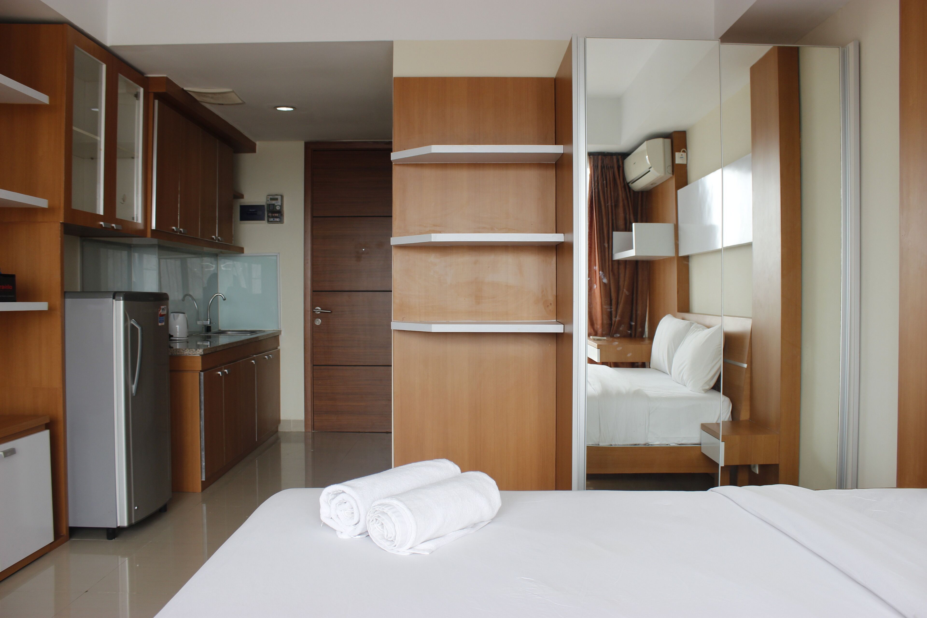 Ein Hotelzimmer mit Bett, Badezimmer und einer Küchenzeile.