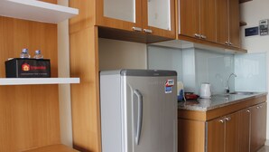 Una cocina con armarios de madera, un refrigerador de acero inoxidable, una cafetera y un dispensador de agua.