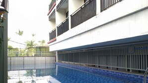 Una piscina con suelo de baldosas y barandilla de metal.