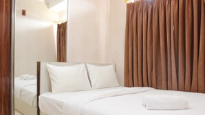 A hotel room with a large bed, a mirror, and curtains. - Cozy 2BR Tamansari Panoramic Apartment (Bandung)