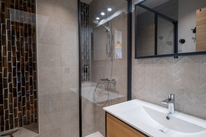 Bathtub, hair dryer, towels, toilet paper