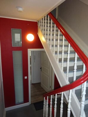 Stairs lead to an upper floor with a door to another room.