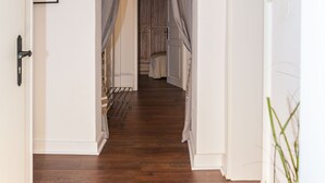 A hallway with wooden flooring, white walls, and a door on the right. - Apartmenthaus Lorbach (Solingen)