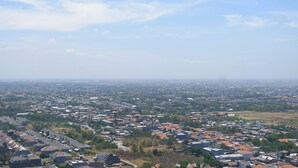 Ein Wohngebiet mit Häusern und Gebäuden, wolkenlosem Himmel und einer entfernten Skyline.