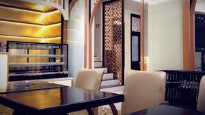 A modern dining area with a wooden table and chairs, a decorative partition, and a glass display case.