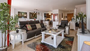 A modern living room with a sofa, coffee table, and a dining area. - Atico Salonica (Javea / Xàbia)