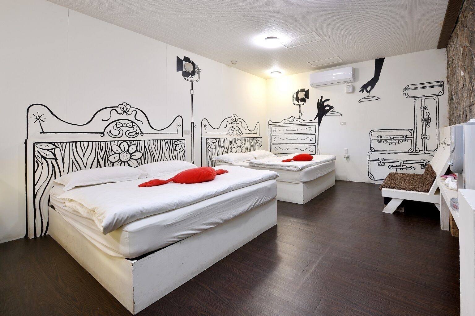 A room with two beds, a dresser, and a TV.