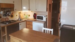 A compact kitchen with white cabinets, a microwave, a small refrigerator, and a toaster. - Relaxation & Skiing in the Heart of the Dolomites UNESCO (Calalzo di Cadore)