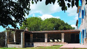 A stone building with a covered patio area, outdoor seating, and a view of a tree and sky. - Marvelous Istrian Villa Morus (Svetvincenat)