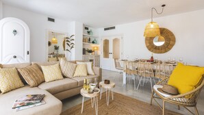 Un salon moderne avec un canapé, une table basse et un coin repas.