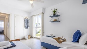 Une chambre d’hôtel moderne équipée d’un lit, d’un canapé, d’un ventilateur de plafond et d’un balcon avec vue.