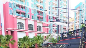 A pirate ship-themed area with a rope barrier, benches, and a backdrop of colorful buildings. - Grande Caribbean Resort - Sleeps 2 (Pattaya)
