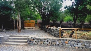 A stone staircase leading to a wooden structure labeled "Organic Retreat NOBRA" in a wooded area. - Nubra Organic Retreat - Hunder - Campsite (Leh)