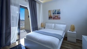 A bedroom with a bed, a nightstand, a lamp, and a painting on the wall.