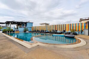 A rooftop swimming pool with lounge chairs, a fire pit, and a colorful fence. - Chana Phuket Patong Hotel (Patong)