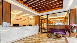 A reception area with a reception desk, a purple sofa, and a patterned floor. - Diamond Crown Hotel Patong (Patong)