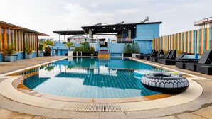 A swimming pool with lounge chairs, a water slide, and a colorful fence. - Diamond Crown Hotel Patong (Patong)