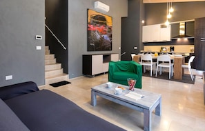 Stylish living space with a staircase, dining area, and modern kitchen.