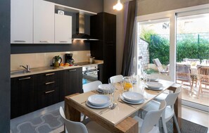 Enjoy meals in this kitchen and dining area with an oven, stainless steel sink, and seating for four.