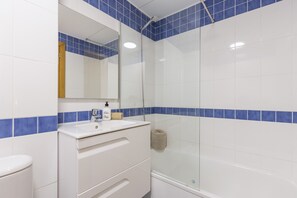 Tina, secadora de cabello, toallas, papel de baño 