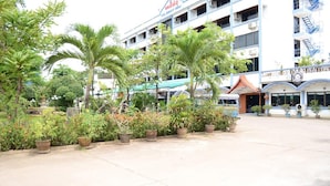 A spacious outdoor area with potted plants and a building with multiple floors and balconies.