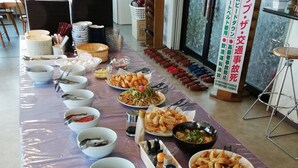 Una larga mesa con diversos platos y fuentes, probablemente dispuesta para una comida o evento.