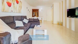 Una sala de estar moderna con un sofá modular, una mesa de centro y un comedor con un armario.