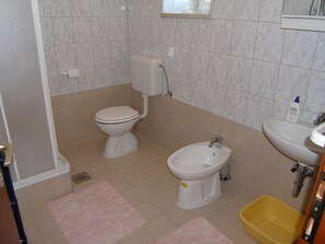 A bathroom with a toilet, bidet, sink, and yellow basin. - Villa Ana - Peaceful Location (Marcana)