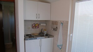 A compact kitchen with white cabinets, a built-in stove, and a sink. - Villa Ana - Peaceful Location (Marcana)