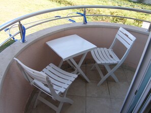 A small outdoor seating area with a table and two chairs, surrounded by a metal railing. - Villa Ana - Peaceful Location (Marcana)