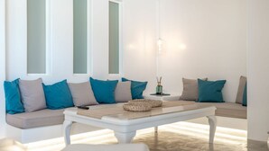 A modern living room with a sofa set, a coffee table, and a lamp.