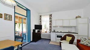 A compact living space with a dining area, kitchenette, and seating area.