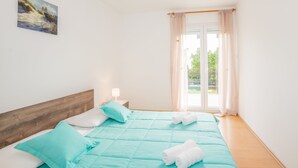 A bedroom with a bed, pillows, a nightstand, and a painting on the wall. - Family house with 2 apartments - Irma (Medulin)