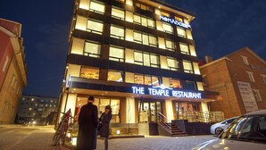 Ein modernes Gebäude mit einem Schild für "The Temple Restaurant" im Erdgeschoss.