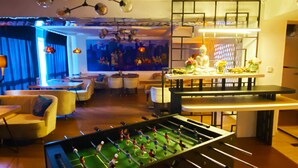 Ein moderner Innenraum mit Tischfußball, Sitzgelegenheiten und einer Bar.