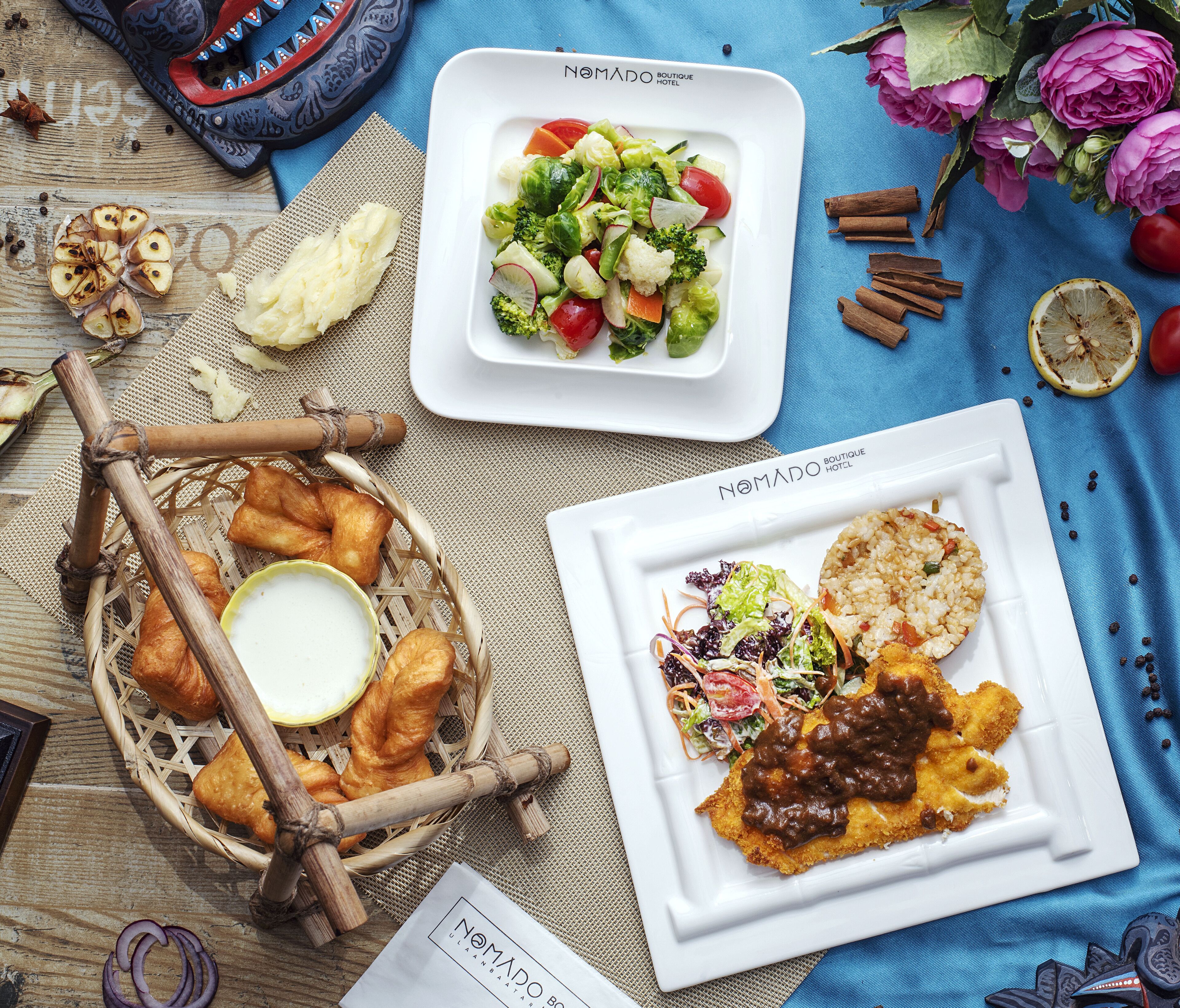 Une table garnie de divers plats, notamment une salade, du pain, et une assiette contenant un plat frit et du riz.