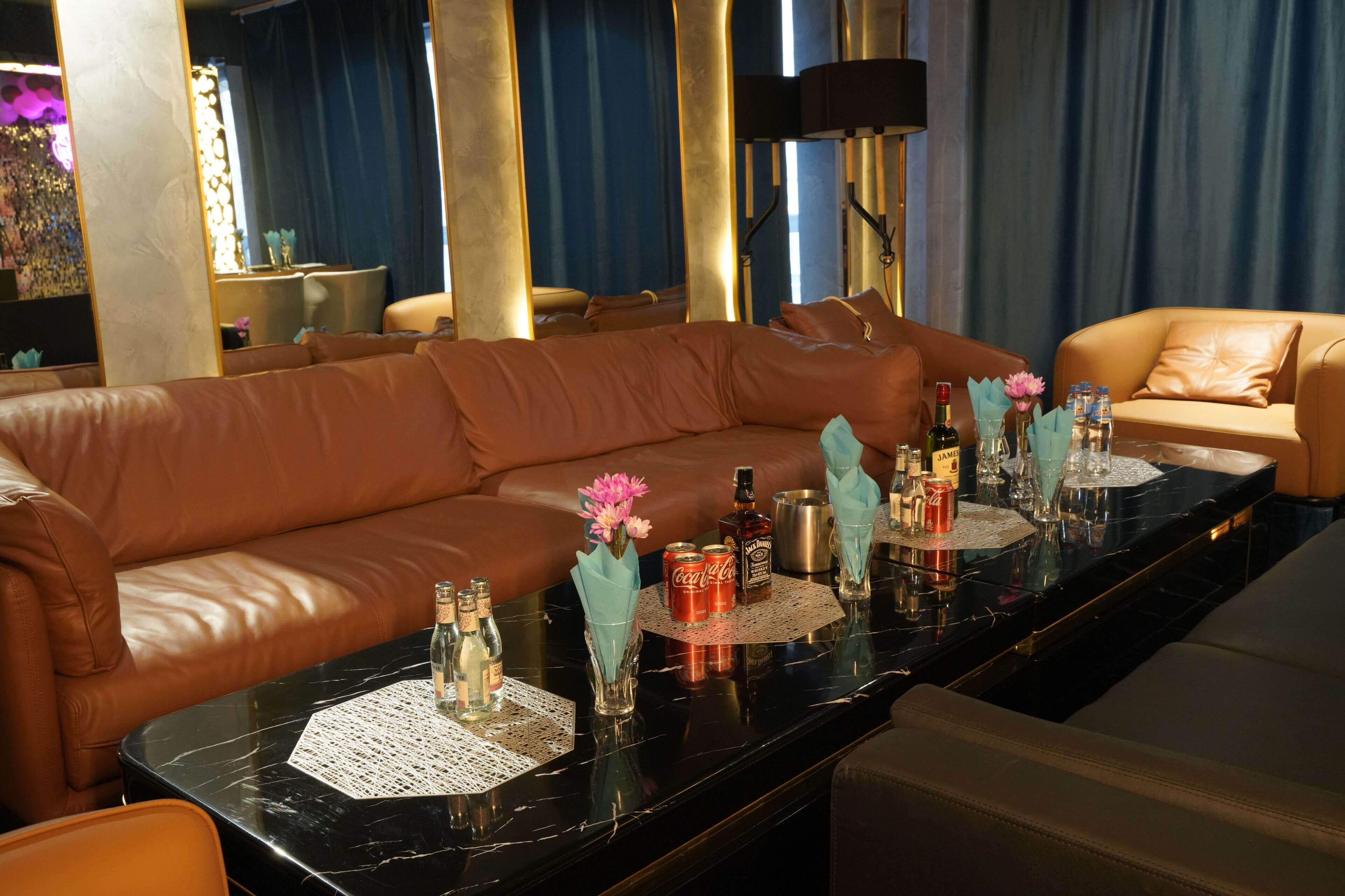 Una sala de estar moderna con sofás de cuero, una mesa de centro de mármol y objetos decorativos.