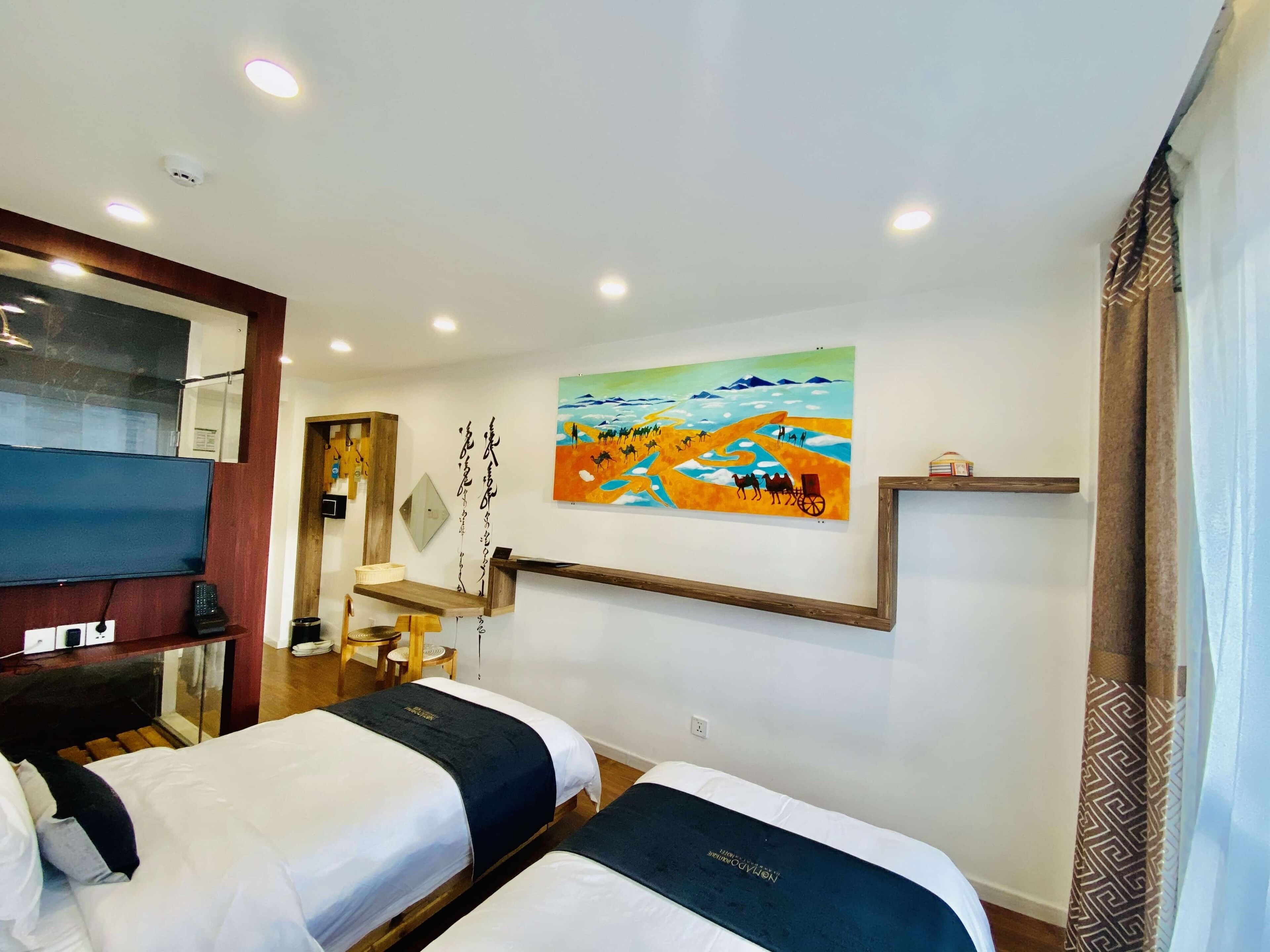 A hotel room with two beds, a TV, a painting on the wall, and a wooden shelf.