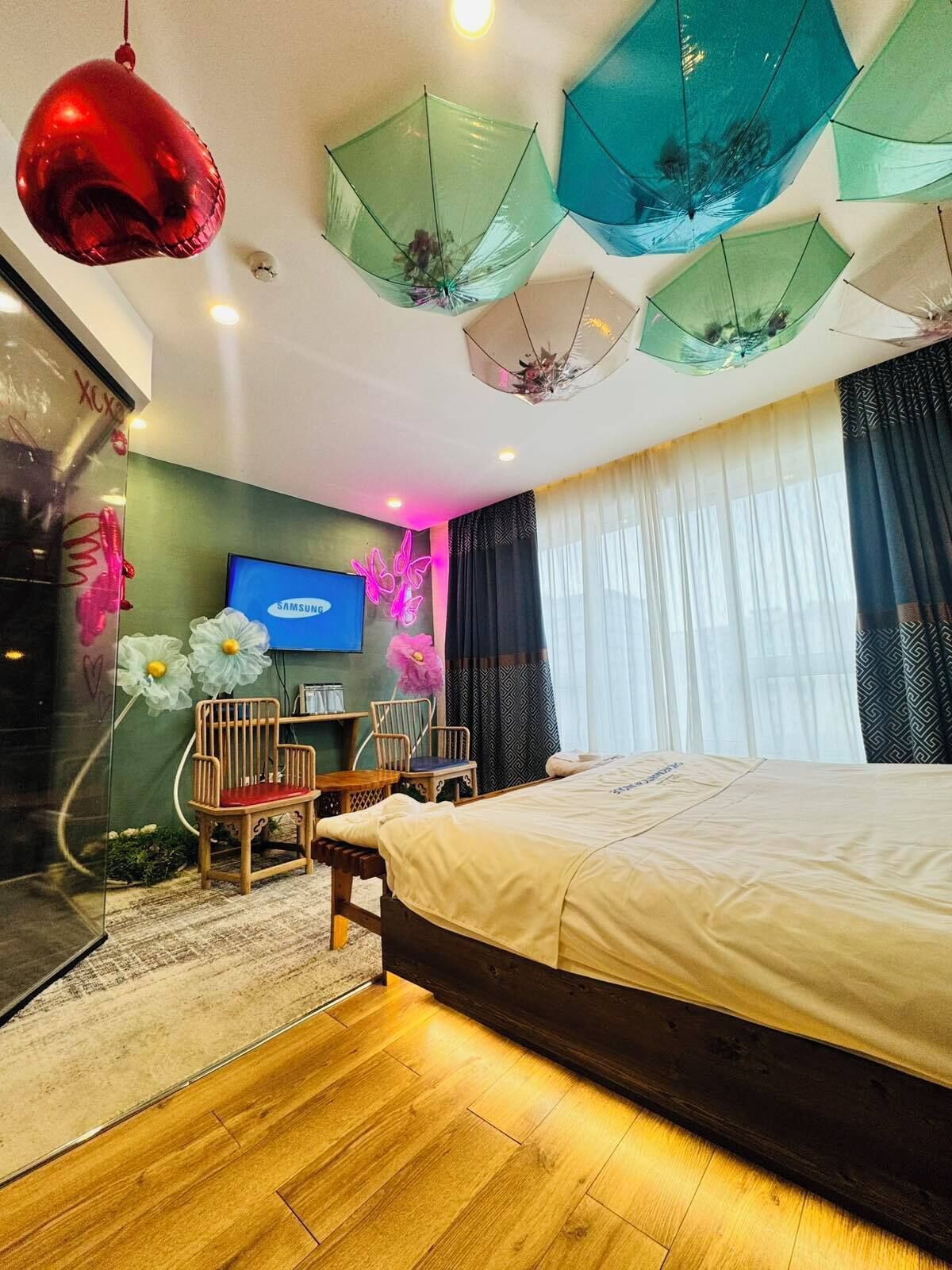 Un dormitorio moderno con una cama, un televisor y paraguas decorativos.