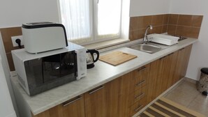 A kitchen with a microwave, toaster, coffee maker, and a sink. - Apartments Cubela Beautiful Garden (Trogir)