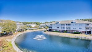 A residential area with a river, modern multi-story buildings, and a clear sky.