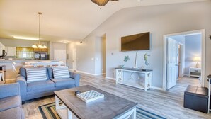 A modern living room with a sofa, coffee table, and a TV mounted on the wall.