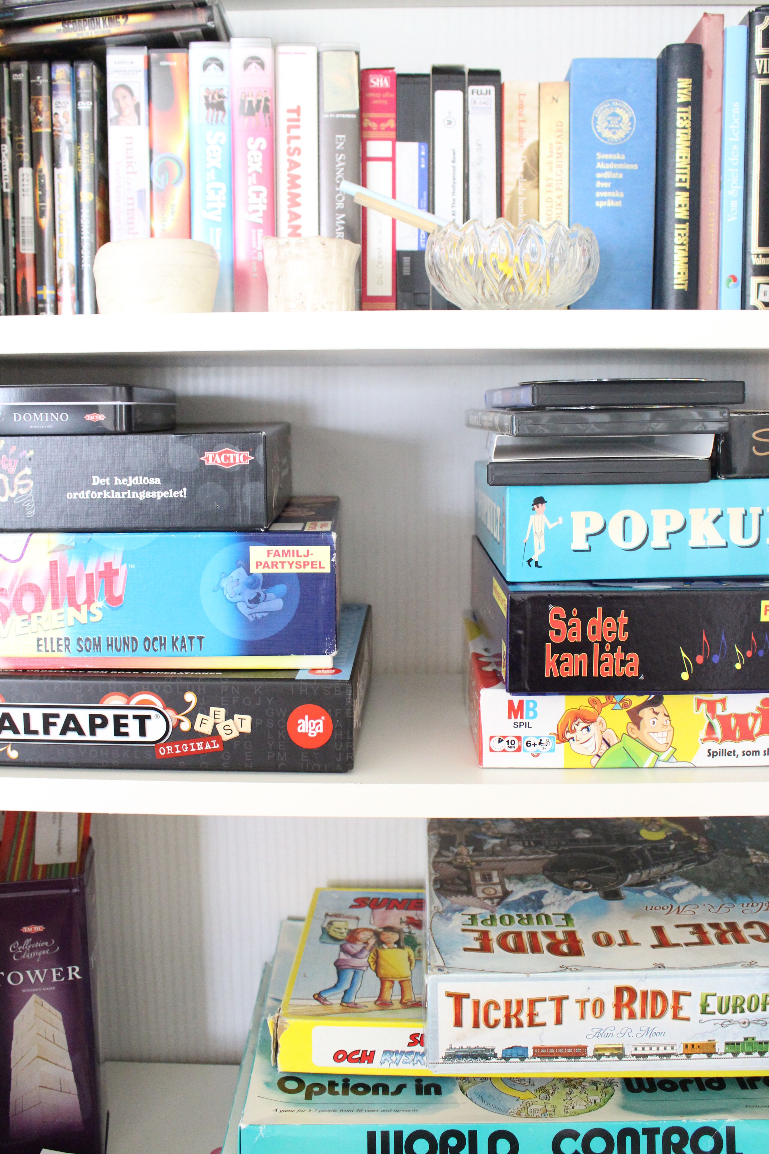 Una estantería con varios libros y juegos de mesa.