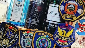 A display of various liquor bottles and police badges. - The Dunvegan Hotel (St. Andrews)