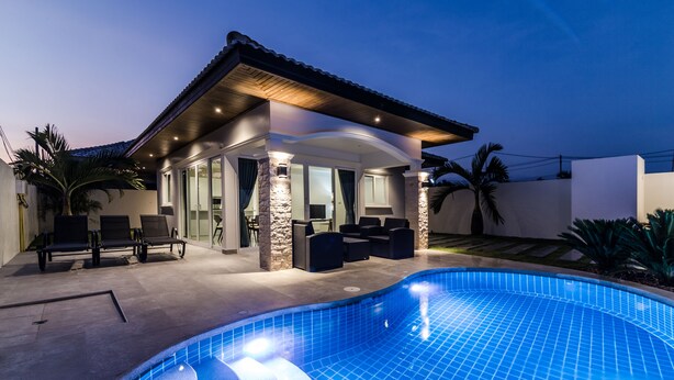 A modern house with a swimming pool, outdoor seating, and a covered patio area. - Orchid Paradise Homes OPV420 (Hua Hin)